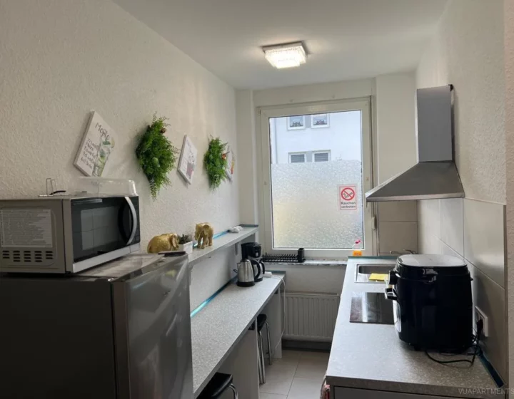 Küche mit Kochfeld, Kühlschrank und Mikrowelle – Apartment 5 in Bochum
