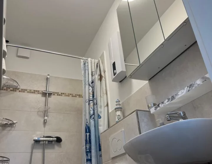 Badezimmer mit Dusche, Waschbecken und Waschmaschine – Apartment 5 in Bochum