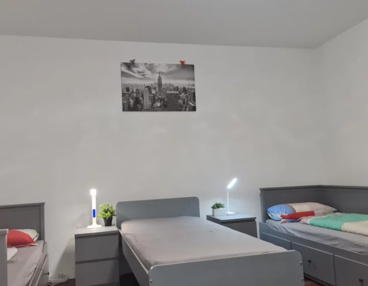Betten und Nachttische im Schlafbereich – Apartment 5 in Bochum
